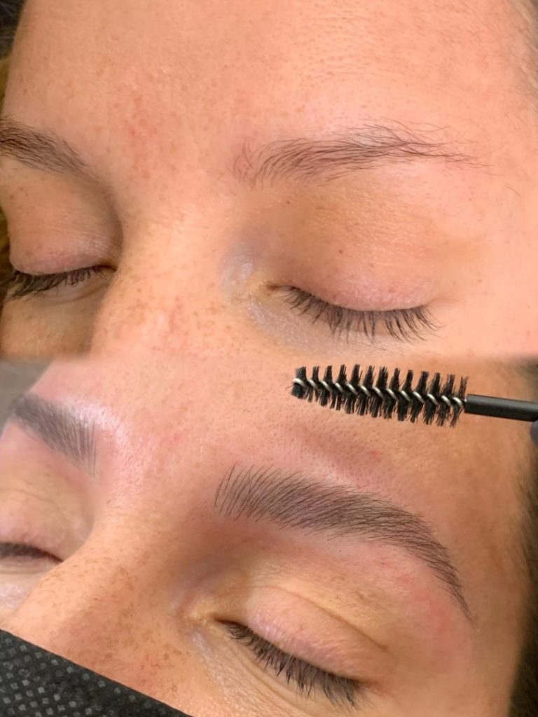 Close-up of a person's eyebrow transformation, showing before (sparse brows) and after (groomed, fuller brows), with a spoolie brush being used on the lower brow.